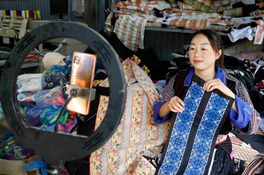 Cu Thi Do, de la etnia Mong, en la comuna de Khao Mang, del distrito de Mu Cang Chai, de la provincia de Yen Bai, vende sus productos de tela de brocado en plataformas de redes sociales. (Fuente: VNA)