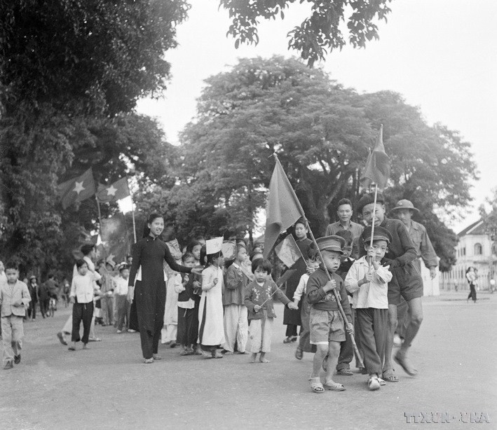 Los niños hanoienes y sus familiares portaron banderas para dar la bienvenida a los soldados que liberaron la capital. (Fuente: VNA)