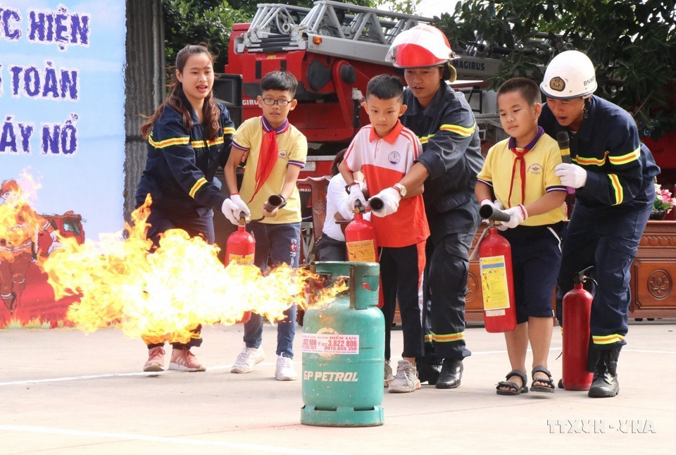 Las fuerzas de prevención y lucha contra incendios de la provincia de Bac Ninh guían a los estudiantes para que experimenten “un día como bombero”. (Foto: VNA)