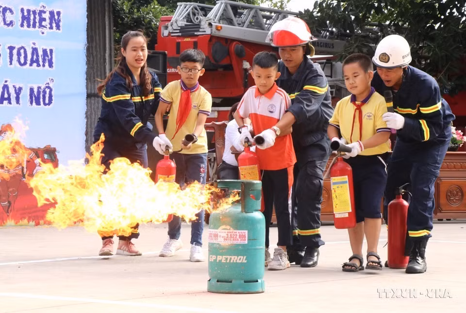 Las fuerzas de prevención y lucha contra incendios de la provincia de Bac Ninh guían a los estudiantes para que experimenten “un día como bombero”. (Foto: VNA)