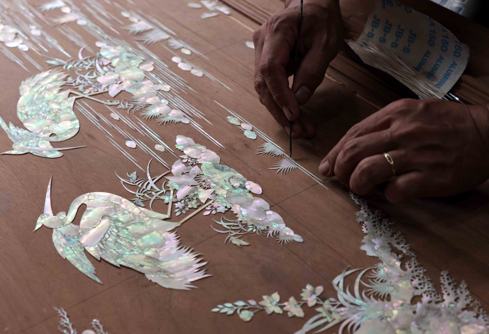 Los artesanos colocan las piezas de nácar sobre la madera. (Foto: VNA)