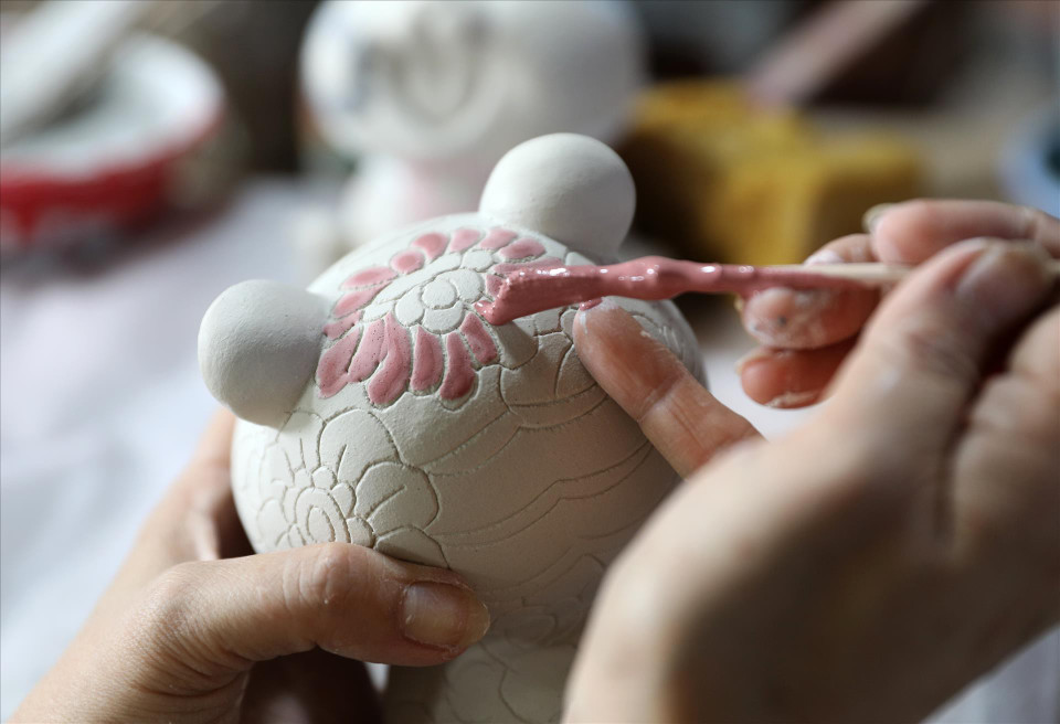 Los artesanos aplican esmalte y dibujan patrones en productos cerámicos de Bien Hoa. (Foto: VNA)