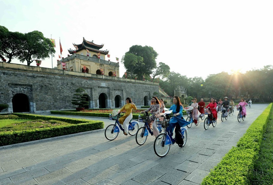 Las mujeres capitalinas vestidas de Ao Dai (túnica tradicional vietnamita) recorren en bicicleta por los sitios patrimoniales de Hanoi. (Foto: VNA)