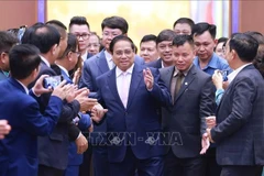 El primer ministro Pham Minh Chinh con empresas que asisten a un seminario sobre desarrollo del sector privado. (Foto: VNA)