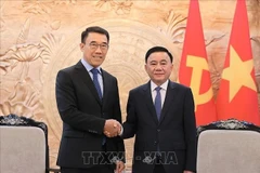 El miembro del Buró Político y permanente del Secretariado del Comité Central del Partido Comunista de Vietnam, Tran Cam Tu, (derecha) recibe al jefe interino de la Comisión de Asuntos Exteriores del Comité Central del Partido Popular Revolucionario de Laos (PPRL), Bounleua Phandanouvong. (Foto: VNA)