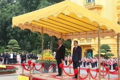 El secretario general To Lam y Díaz-Canel en la tribuna de honor, escuchando las bandas militares interpretar los himnos nacionales de Vietnam y Cuba. Foto: VNA