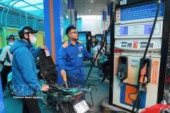 Clientes compran gasolina en una estación de servicio de Petrolimex. (Foto: VNA)