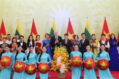 El presidente vietnamita Luong Cuong y su esposa, el presidente lituano Gitanas Nauseda y su esposa, con artistas vietnamitas. (Foto: VNA)