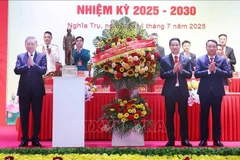 El secretario general To Lam (izquierda) entrega una cesta de flores para felicitar a la asamblea del Comité partidista de la comuna de Nghia Tru del período 2025-2030. (Foto: VNA)