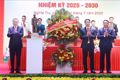 El secretario general To Lam (izquierda) entrega una cesta de flores para felicitar a la asamblea del Comité partidista de la comuna de Nghia Tru del período 2025-2030. (Foto: VNA)