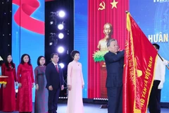 El secretario general del Partido Comunista de Vietnam, To Lam, coloca la Orden Ho Chi Minh en la bandera de la VNA. (Foto: VNA)