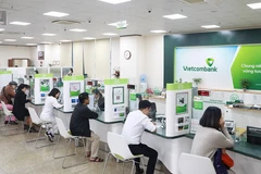 Clientes realizan transacciones en el banco Vietcombank. (Foto: hanoimoi.vn)