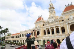 Visitantes internacionales exploran el centro de Ciudad Ho Chi Minh en un autobús de dos pisos. (Foto: VNA)