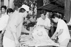 Ciudadanos de Hanoi compran el "Noticiero vespertino" de la VNA para seguir las noticias de la clausura del VII Congreso Nacional del Partido (17 de julio de 1991). Foto: Huu Oai - VNA