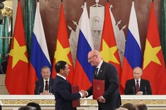 El secretario general To Lam y el presidente Vladimir Putin presenciaron la entrega, por parte del viceprimer ministro y canciller vietnamita Bui Thanh Son y del viceprimer ministro ruso Dmitry Chernyshenko, del Acuerdo sobre cooperación en el sector de petróleo y gas y del Protocolo sobre el funcionamiento de las empresas conjuntas Vietsovpetro y Rusvietpetro. (Foto: VNA)