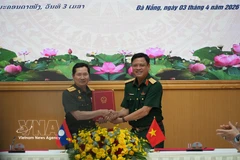 El coronel general Nguyen Truong Thang, viceministro de Defensa de Vietnam, (derecha) y su homólogo laosiano, coronel general Saichay Kommasith, intercambian el acta de diálogo. (Foto: VNA)