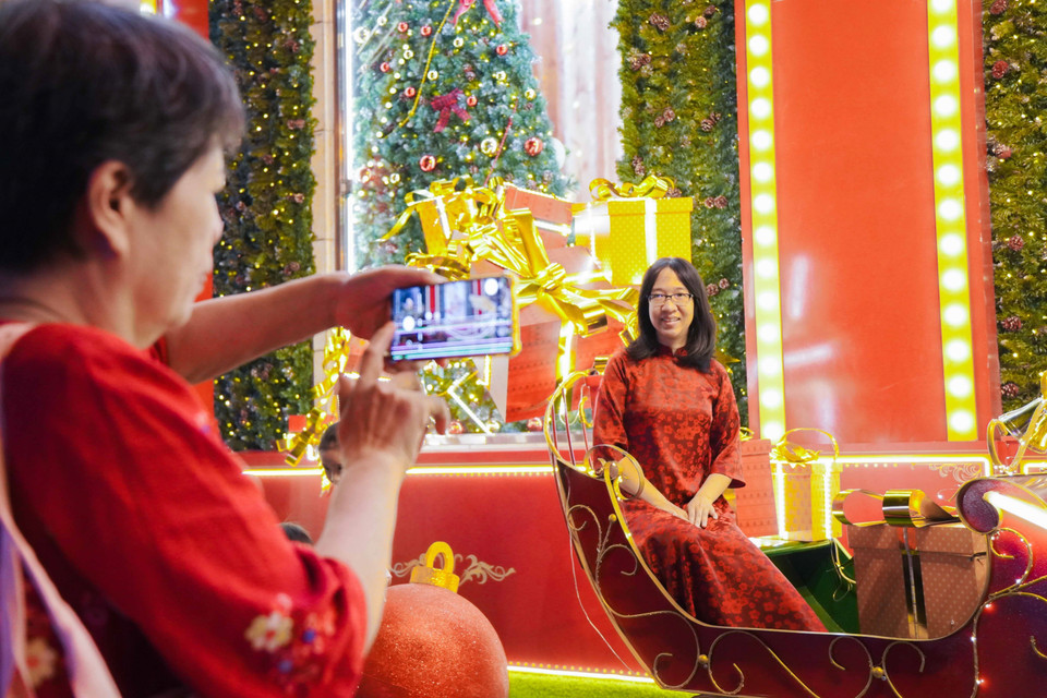 Muchas personas eligen el rojo como color principal para capturar los momentos navideños. (Foto: VNA)