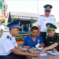 Las autoridades pertinentes movilizan a los pescadores a firmar un compromiso para combatir la pesca ilegal en el puerto pesquero de Cua Viet. (Foto: VNA)
