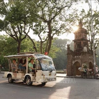 Turistas recorren el lago Hoan Kiem en coches eléctricos. (Foto: VNA)