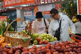 Extranjeros compran frutas en un mercado vietnamita. (Fuente: VNA)