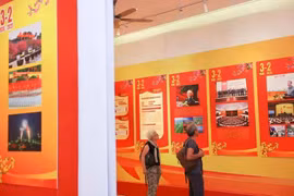 Turistas internacionales visitan una exposición por el aniversario 95 de la fundación del Partido Comunista de Vietnam. (Fuente: VNA)