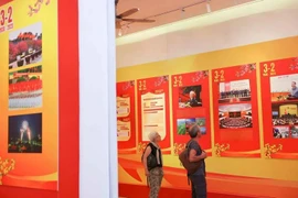 Turistas internacionales visitan una exposición por el aniversario 95 de la fundación del Partido Comunista de Vietnam. (Fuente: VNA)