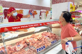 Una cliente compra carne de cerdo en el supermercado Coopmart en Ciudad Ho Chi Minh (Fuente: VNA)