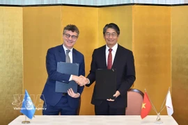 Jonathan W. Baker, representante jefe de la UNESCO en Vietnam, y el embajador Ito Naoki firman un acuerdo para implementar el proyecto. (Foto: baoquocte.vn)