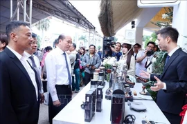 Los delegados visitan un stand que exhibe las máquinas y equipos para preparar café en la feria (Fuente: VNA)