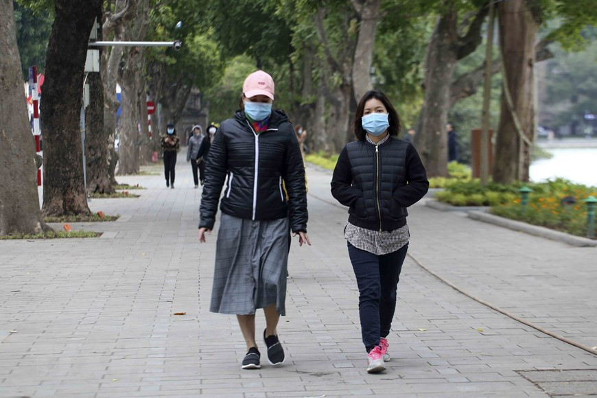La gente está bien abrigada al caminar por el lago Hoan Kiem en la mañana. (Fuente: VNA)