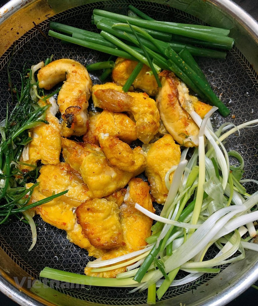 El Cha Ca suele elaborarse a base de pescado Lang (Hemibagrus guttatus), el cual tiene la piel suave y pocas espinas, con carne dulce, sabrosa y aromática. El secreto para preparar el delicioso platillo es la etapa de marinado. Tras limpiar y cortar el pescado en trozos, se adoba con cúrcuma, ajo, cebolla, galanga, sal, azúcar, salsa de pescado y salsa de camarones. Luego se asa con carbón de leña. Las porciones asadas se fríen a fuego lento en una sartén con eneldo y cebollino para después servirse con fideos de arroz, una típica salsa compuesta de salsa de camarones, zumo de limón y un poco de azúcar, y diversas hierbas aromáticas como culantro, cilantro y menta. (Foto: Vietnam +) 