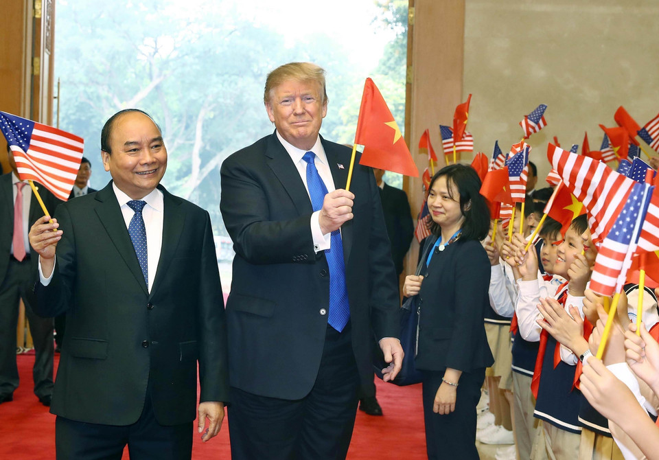 El primer ministro vietnamita, Nguyen Xuan Phuc, y los niños de Hanoi dan la bienvenida al presidente de Estados Unidos, Donald Trump, el 27 de febrero de 2019, en la sede del Gobierno. (Foto: VNA)