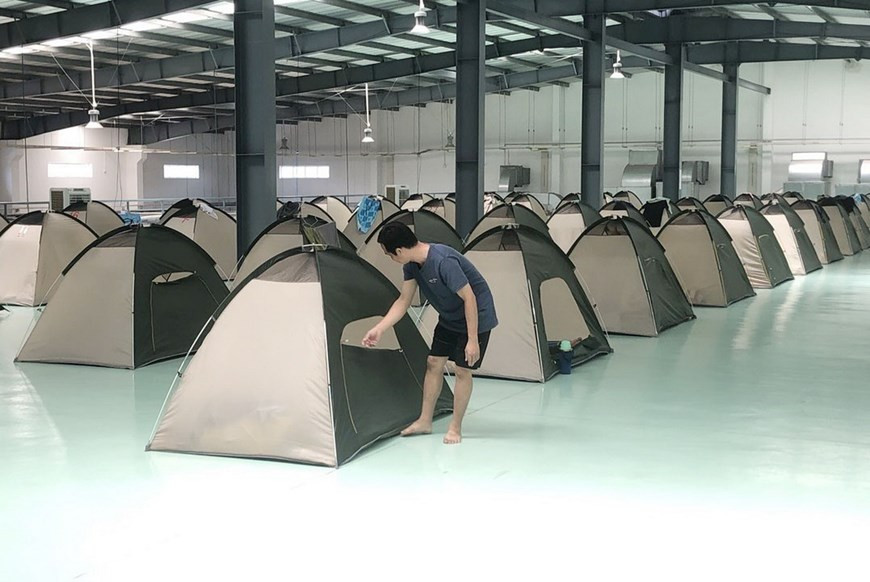 Los trabajadores de la empresa Daikan Vietnam implementan la medida "tres in situ" (comer en el lugar, descansar en el lugar y trabajar en el lugar) para garantizar la producción. (Foto: VNA)