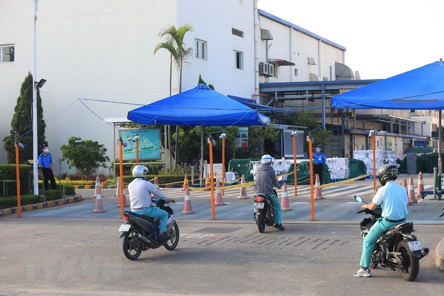 Los trabajadores de la empresa TOTO Vietnam, en el parque industrial de Thang Long-Hanoi, deben utilizar los pasillos divididos. (Foto: VNA)