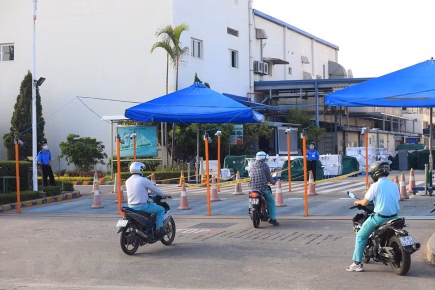 Los trabajadores de la empresa TOTO Vietnam, en el parque industrial de Thang Long-Hanoi, deben utilizar los pasillos divididos. (Foto: VNA)