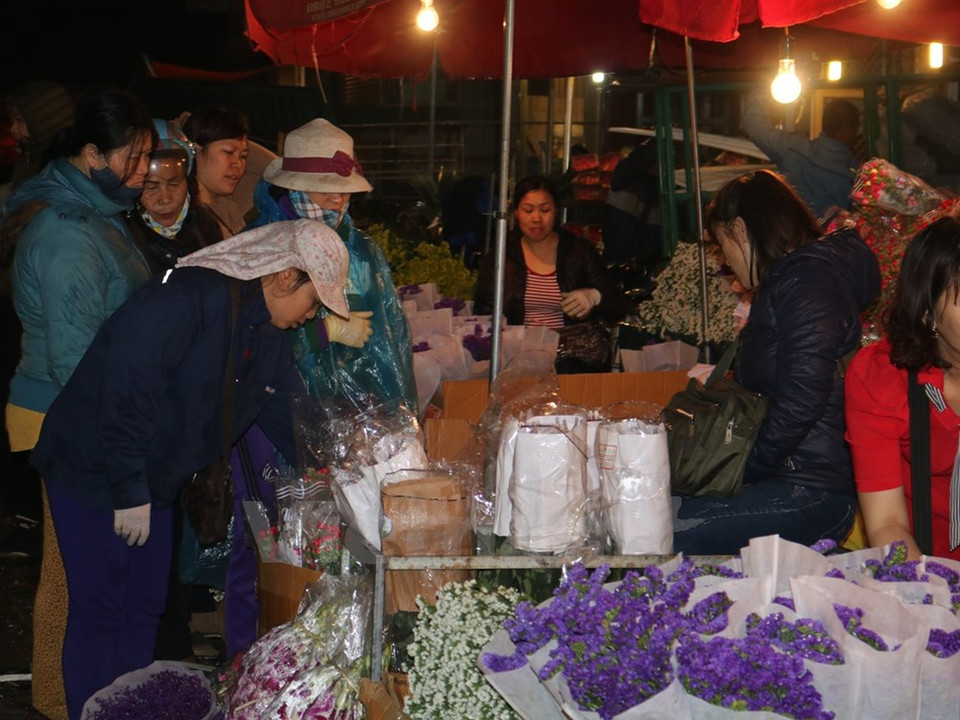 Varias personas acuden al mercado de flores de Quang An dese la madrugada (Fuente: VNA)