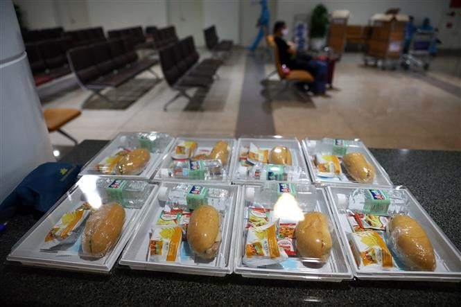 Mientras esperan que las muestras se analicen y se clasifiquen en el área aislada, los pasajeros reciben comidas gratis. (Foto: VNA)