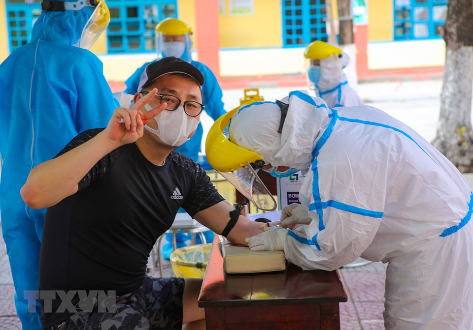 Extranjeros proporcionan información médica antes de tomar muestras en el distrito de Son Tra, en Da Nang. (Foto: VNA)