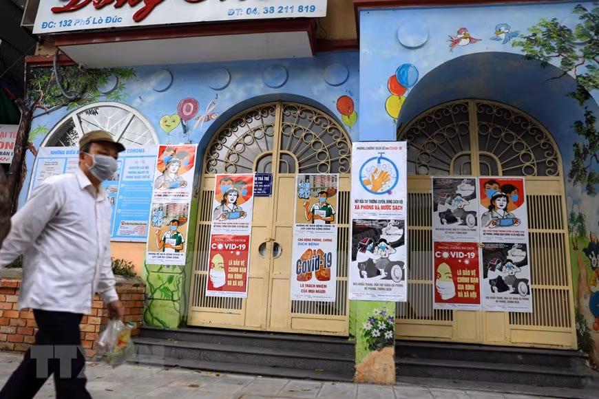 Se cuelgan carteles en la entrada de la sede y las escuelas de las autoridades locales (Foto: VNA)
