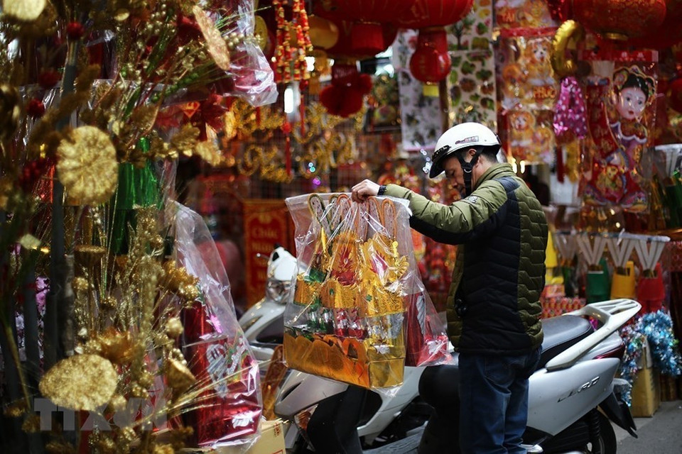Por tan significativo acontecimiento, todos los hogares vietnamitas están ocupados preparando platos típicos y bebidas en ofrenda a esas deidades guardianas de la cocina. Se elaboran de manera cuidadosa las ofrendas, se queman ropas hechas de papel, de color rojo (símbolo de la buena suerte y la prosperidad), incluidos sombreros, mantos y calzados para rendir culto a esas divinidades (dos masculinas y una femenina), que son las que protegen a todas las familias en las cocinas de las casas. Foto: Hacen las compras preparatorias del rito dedicado a dioses de cocina (Fuente: VNA)