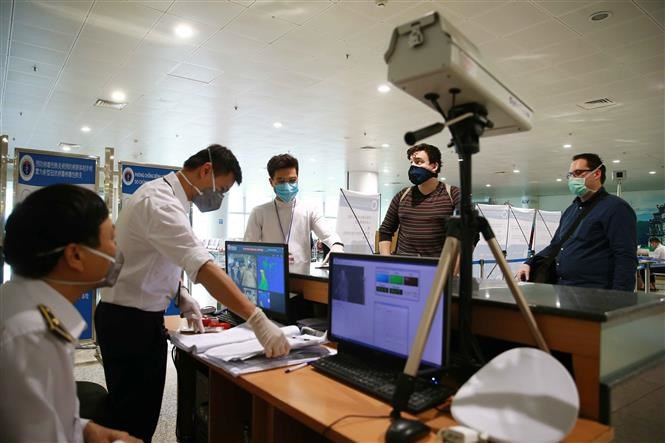 Los pasajeros a la entrada se controlan la temperatura corporal (Foto: VNA)