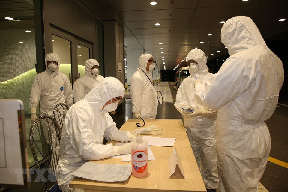 El personal del aeropuerto Van Don realizó los trámites de migración para los viajeros que regresaron de Wuhan (China). (Foto: VNA)