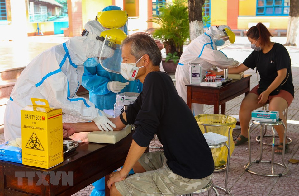 Extranjeros toman muestras para realizar pruebas en el distrito de Son Tra, en Da Nang. (Foto: VNA)