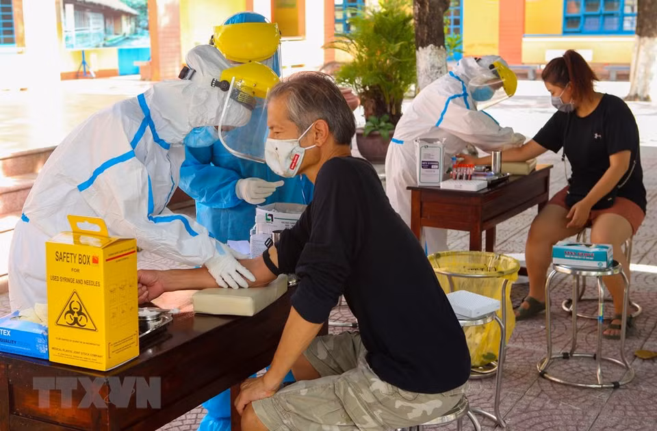 Extranjeros toman muestras para realizar pruebas en el distrito de Son Tra, en Da Nang. (Foto: VNA)