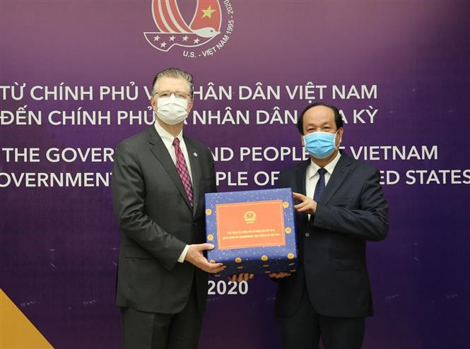 El jefe de la Oficina del Gobierno vietnamita, ministro Mai Tien Dung, en nombre del premier Nguyen Xuan Phuc, entrega la donación al embajador estadounidense, Daniel J. Kritenbrink (Foto: VNA)