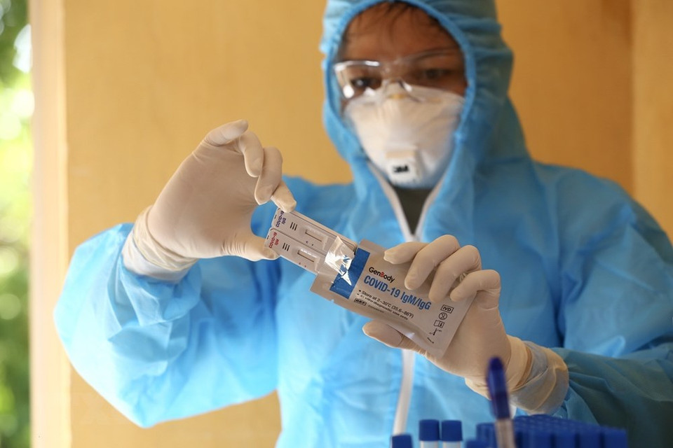 Los trabajadores de la salud preparan el kit de prueba rápida SARS-CoV-2 para personas en la comuna de Mai Dinh, distrito de Soc Son. (Foto: VNA)