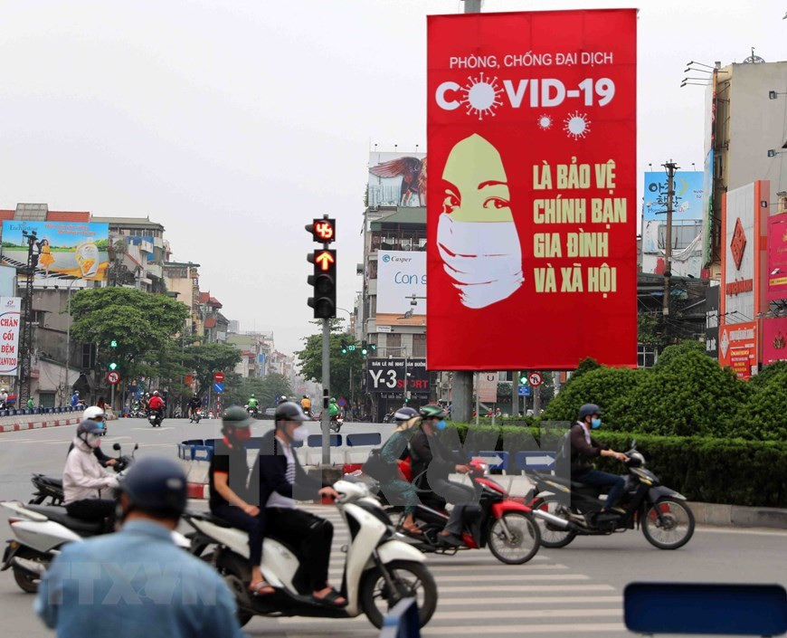 Carteles para concientizar sobre la prevención y el control de COVID-19 en las principales calles de Hanoi (Foto: VNA)