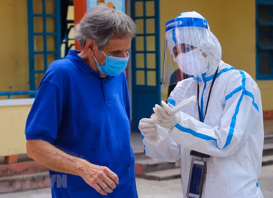 Extranjeros proporcionan información médica antes de tomar muestras en el distrito de Son Tra, en Da Nang. (Foto: VNA)