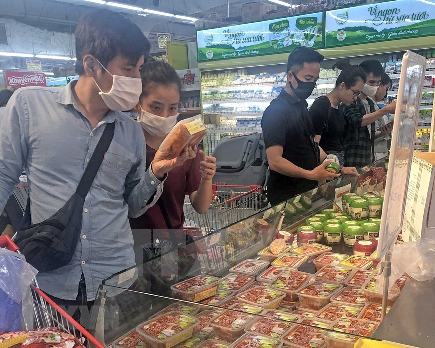 Los clientes seleccionan productos en el supermercado Big C Thang Long en Hanoi (Foto: VNA)