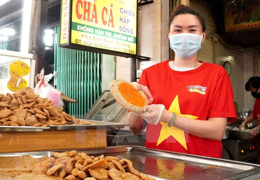 Los vendedores del mercado de Han, en la ciudad de Da Nang, usan camisetas de la bandera nacional para mostrar su firmeza en la lucha contra el coronavirus (Foto: VNA)